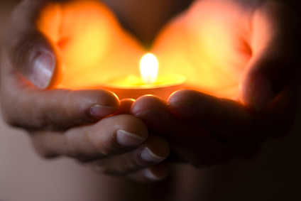 Hands holding candle--hope illuminates