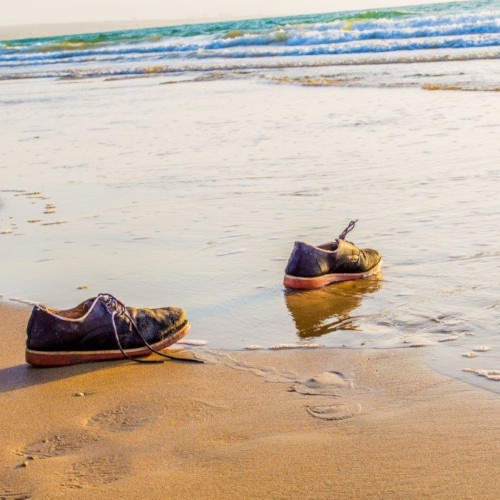 Empty shoes by the sea